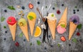 Various of ice cream flavor in cones blueberry ,green tea ,pistachio ,almond ,orange and cherry setup on dark stone background . Royalty Free Stock Photo