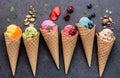 Various of ice cream flavor in cones blueberry ,strawberry ,pistachio ,almond ,orange and cherry setup on dark stone background .