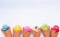 Various of ice cream flavor in cones blueberry ,strawberry ,pistachio ,almond ,orange and cherry setup on white wooden background Royalty Free Stock Photo