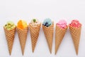 Various of ice cream flavor in cones blueberry ,strawberry ,pistachio ,almond ,orange and cherry setup on white wooden background Royalty Free Stock Photo