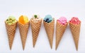 Various of ice cream flavor in cones blueberry ,strawberry ,pistachio ,almond ,orange and cherry setup on white wooden background Royalty Free Stock Photo