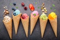 Various of ice cream flavor in cones blueberry ,strawberry ,pistachio ,almond ,orange and cherry setup on dark stone background . Royalty Free Stock Photo