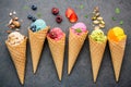 Various of ice cream flavor in cones blueberry ,strawberry ,pistachio ,almond ,orange and cherry setup on dark stone background . Royalty Free Stock Photo