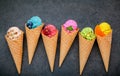 Various of ice cream flavor in cones blueberry ,strawberry ,pistachio ,almond ,orange and cherry setup on dark stone background . Royalty Free Stock Photo