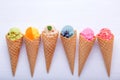 Various of ice cream flavor in cones blueberry ,strawberry ,pistachio ,almond ,orange and cherry setup on white wooden background Royalty Free Stock Photo