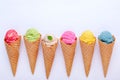 Various of ice cream flavor in cones blueberry ,strawberry ,pistachio ,almond ,orange and cherry setup on white wooden background Royalty Free Stock Photo