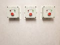 Electrical control panel with red button on concrete wall, closeup