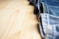 Various jeans pants on wooden background, place for text. Close-up Royalty Free Stock Photo