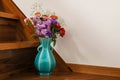 Various kind of flowers in a blue vase on the stairs. Royalty Free Stock Photo