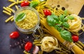 Various kinds of pasta ingredients with basil, cherry tomato, garlic, pepper and cheese Royalty Free Stock Photo