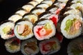 Various kinds of sushi roll set served on black stone. Japanese food