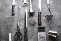 Various kitchen utensils on a gray table background, top view