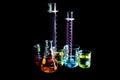Various laboratory beakers and cylinders filled with colorful liquids o