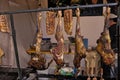 Various large smoked cuts of meat are suspended from a metal rack.