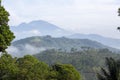 the various layers of hills and the upright mountains stand firm and are crossed by clouds in the morning