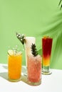 Various lemonade drink over green background. White table with sunlight and palm leaf hard shadow. Summer, tropical and juicy Royalty Free Stock Photo