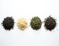 Various loose tea piles sit on clean white surface. Different types of dry tea leaves include black, white, green, aromatic Royalty Free Stock Photo