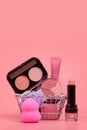 Various make-up products and brushes in shopping cart on pink background. Makeup cosmetics sale concept Royalty Free Stock Photo