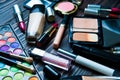 Various makeup products on dark background. Cosmetics make up artist objects: lipstick, eye shadows, eyeliner, concealer Royalty Free Stock Photo