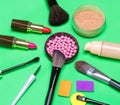 Various makeup products on green background Royalty Free Stock Photo