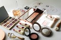 Various makeup products on white table