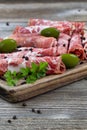 Various meats on serving board with rustic background Royalty Free Stock Photo