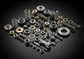 Various metal machine components, including gears, springs, bolts, and nuts, are arranged on a Royalty Free Stock Photo