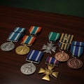 Various military medals are displayed on a dark wooden surface. They include silver, Royalty Free Stock Photo
