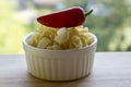 Various mix of pasta in white baking bowl on wooden table and ripened red jalapeno pepper Royalty Free Stock Photo