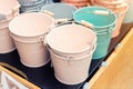 Various multicolored bright small ornamental metal buckets for sale on wooden table outdoors. Many colorful decorative mini pails Royalty Free Stock Photo