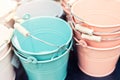 Various multicolored bright small ornamental metal buckets for sale on wooden table outdoors. Many colorful decorative mini pails Royalty Free Stock Photo