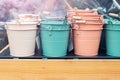 Various multicolored bright small ornamental metal buckets for sale on wooden table outdoors. Many colorful decorative mini pails Royalty Free Stock Photo