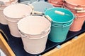 Various multicolored bright small ornamental metal buckets for sale on wooden table outdoors. Many colorful decorative mini pails Royalty Free Stock Photo