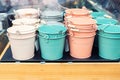 Various multicolored bright small ornamental metal buckets for sale on wooden table outdoors. Many colorful decorative mini pails Royalty Free Stock Photo