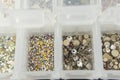 Various nail art beads, gemstones and accessories neatly organized in clear containers