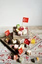 various national Oriental sweets, with paper flags of Turkey, Turkish delight on a wooden white brushed stand and on a white brush Royalty Free Stock Photo