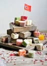 various national Oriental sweets, with paper flags of Turkey, Turkish delight on a wooden white brushed stand and on a white brush Royalty Free Stock Photo