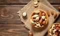 Various nuts in bowl - cashew, hazelnuts, almonds, brazilian nuts and macadamia on a wooden background.