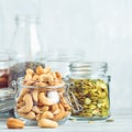 Various nuts and seeds in glass jars over white wooden table against white background. Royalty Free Stock Photo