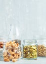 Various nuts and seeds in glass jars over white wooden table against white background Royalty Free Stock Photo