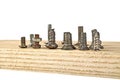 Various old screws on wooden plank on white background Royalty Free Stock Photo