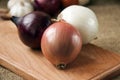 Various onions on a board on a background sacking, burlap Royalty Free Stock Photo