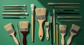 Various paintbrushes are arranged on a green background. Brushes vary in size and Royalty Free Stock Photo