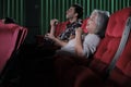 Various people enjoy watching funny cinema in movie theaters.