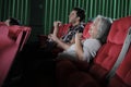 Various people enjoy watching funny cinema in movie theaters.