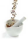 Various peppercorns falling into mortar and pestle Royalty Free Stock Photo