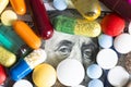 Various pills on American dollars banknotes, cost of medicine concept