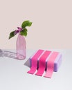 Various pink fitness elastic bands and purple yoga block on pastel beige background. Glass bottle and beautiful magnolia flower.