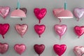 Various pink heart shaped foil baloons on a wall land lamps love concept, Holiday celebration, Valentine`s Day