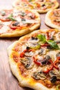 Various Pizzas on wooden table